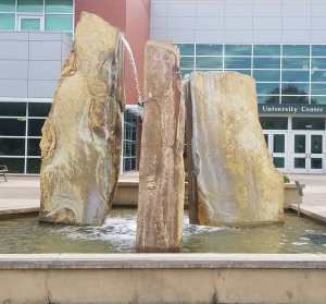The image shows a water fountain composed of three large stones.