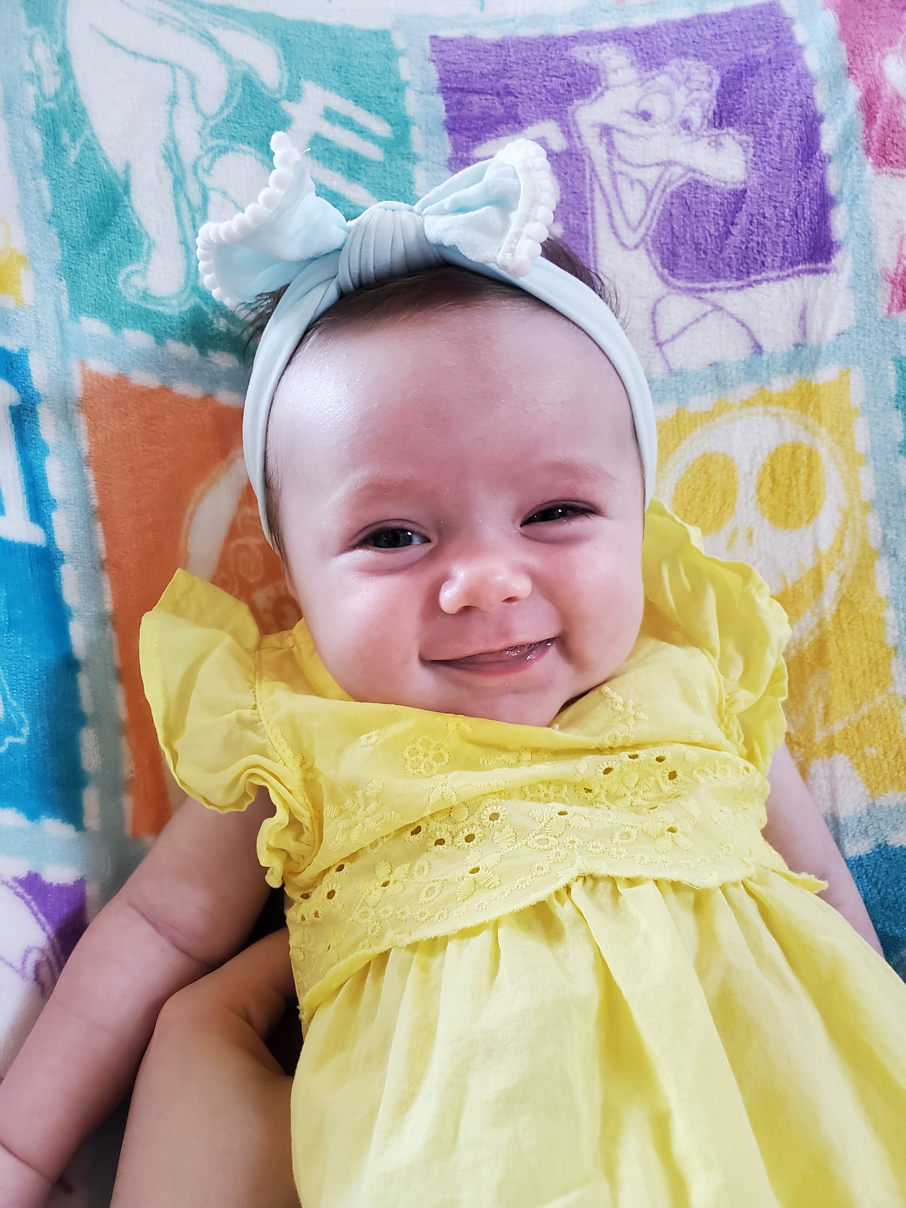 Baby wearing a yellow romper and blue headband